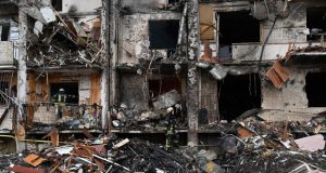 Megsérült lakóépületnél dolgoznak a tűzoltók Kijevben 2022. február 25-én (Fotó: AFP/Genya Savilov